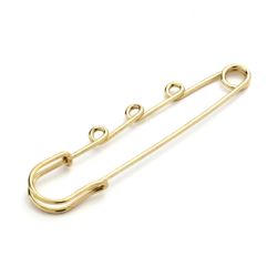 Epingle kilt dorée à volutes características